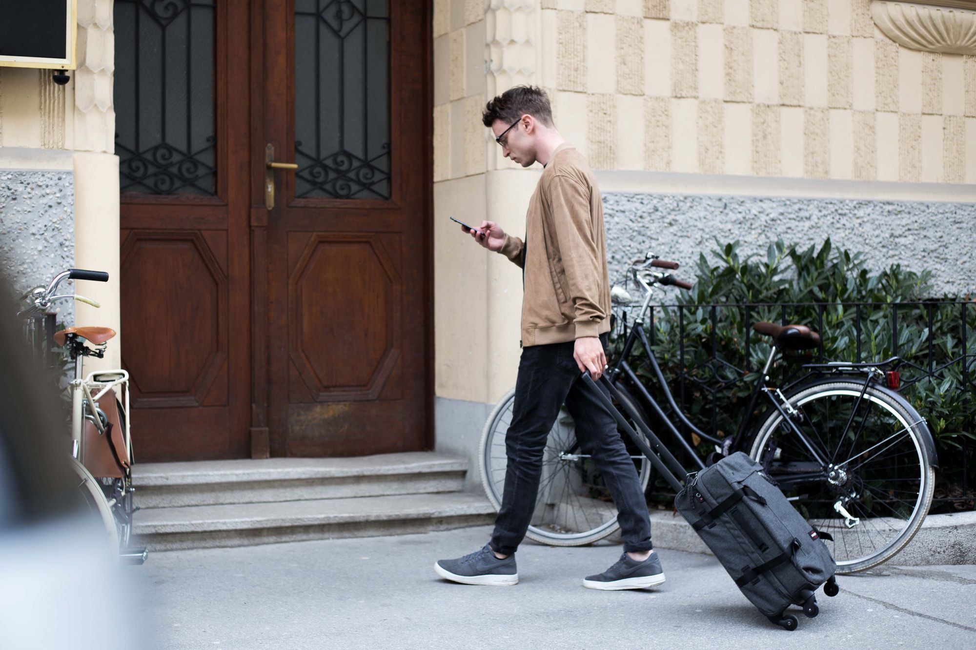 Man-outside-apartment-with-suitcase